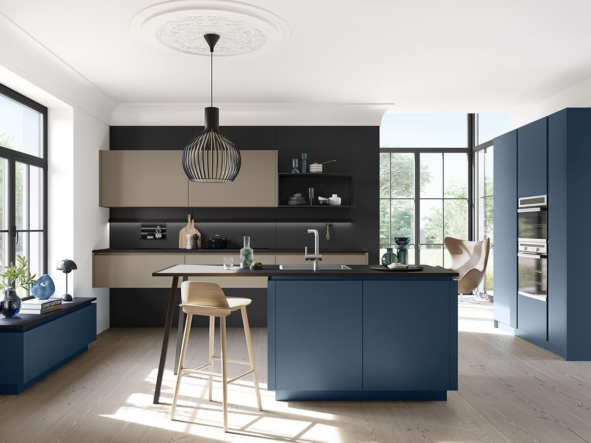 Offene Küche Blau Eine dunkelbeige Küche vor schwarzer Wand mit dunkelblauer Insel und bodentiefen Fenstern