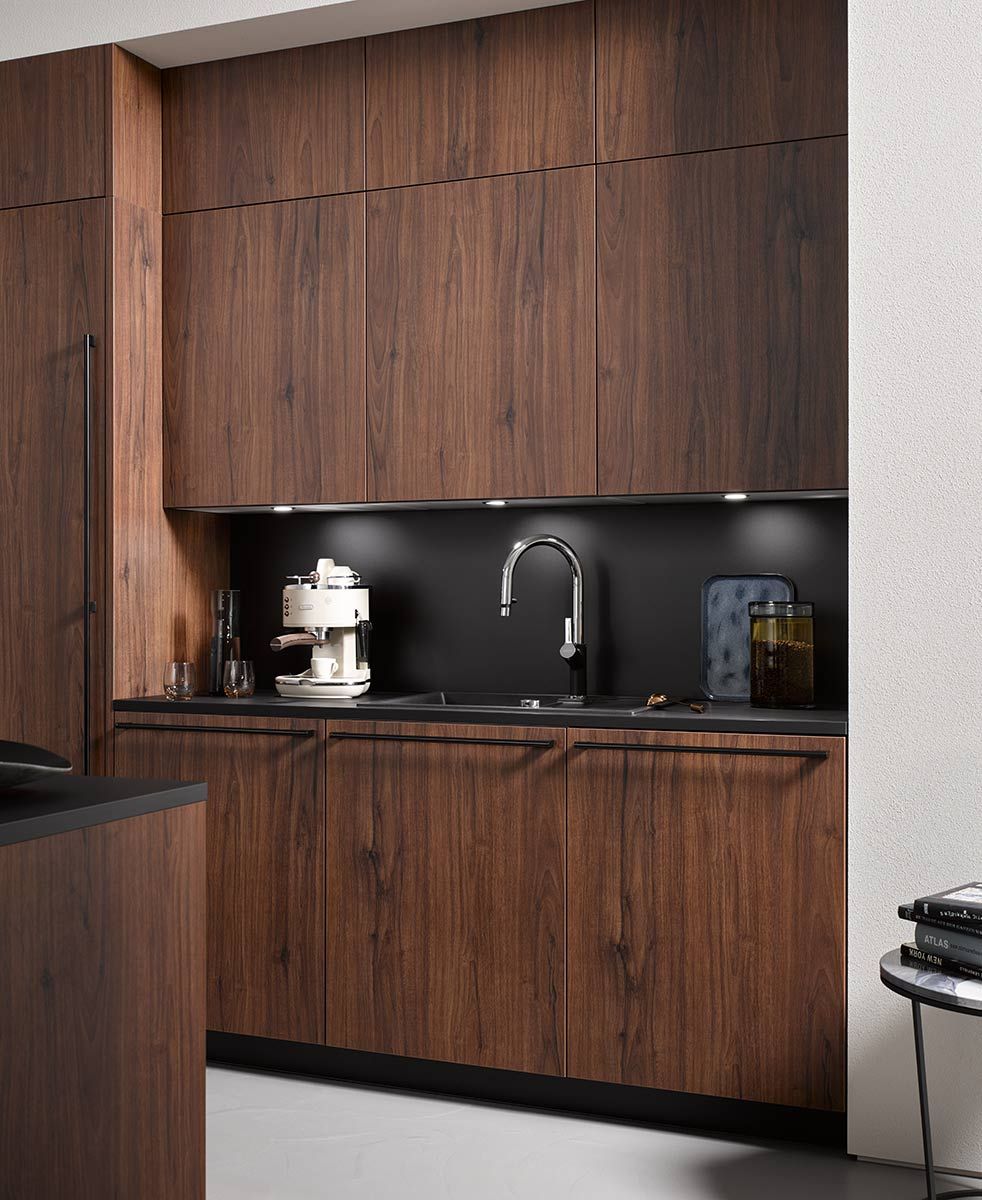 Dunkle Holzküche Eine dunkel verkleidete Holzküche an weißer Wand
