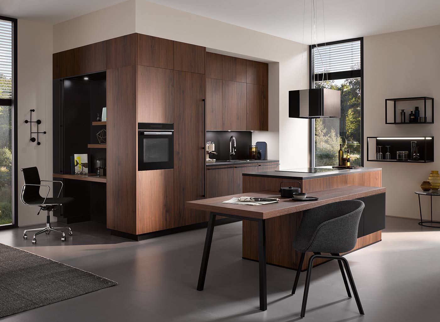 Dunkle Holzküche Eine Holzküche mit Esstisch integriert in der Kochinsel und einem Schreibtisch seitlich im Wandschrank