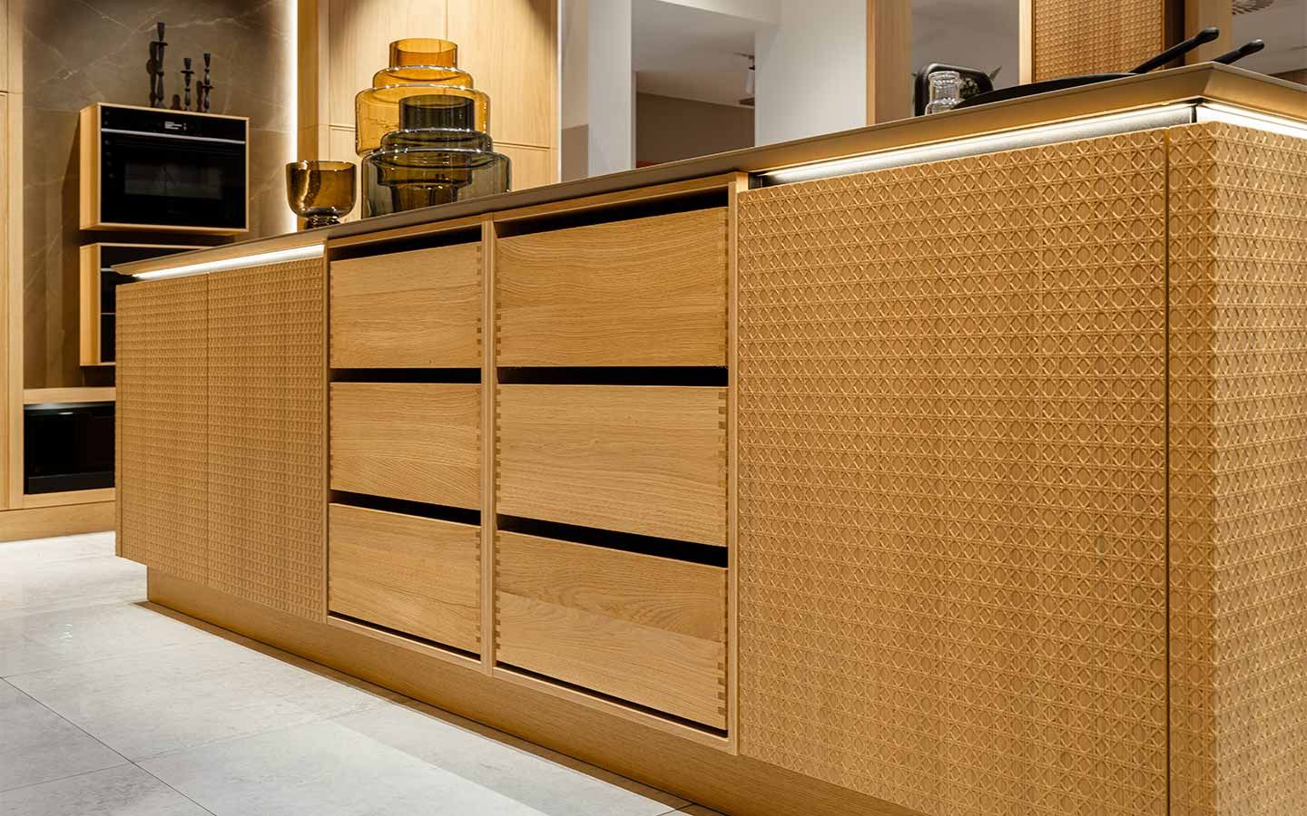 Helle Kochinsel aus Holz Eine Kochinsel aus hellem Holz mit bemusterter Holzverkleidung