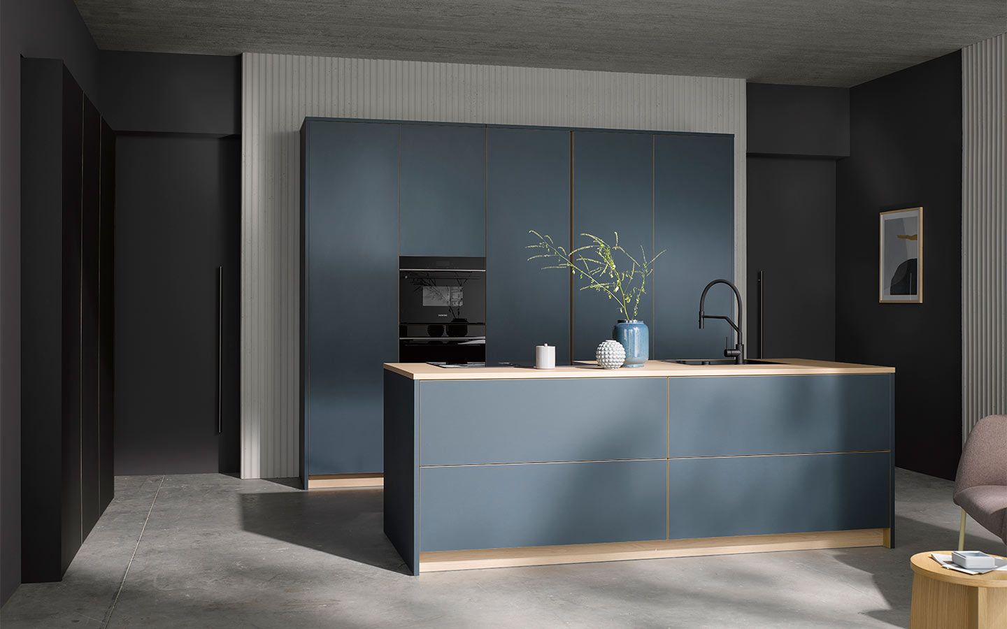 Blaue Küche vor weißer Wand Eine Blaue Küche vor einem weißen Wandabschnitt in einer schwarzen Wand