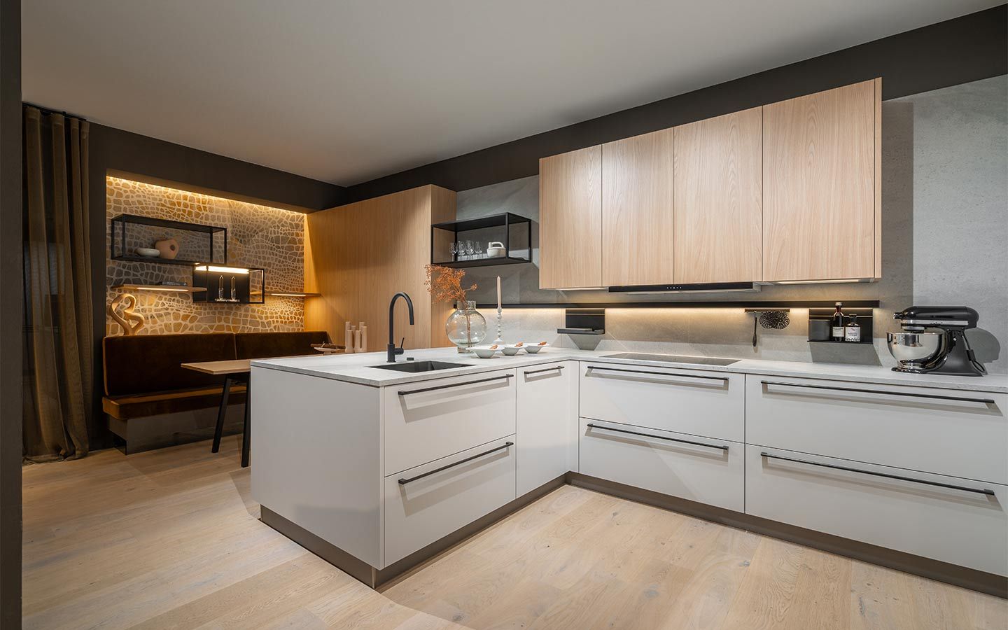 Weiße Küche mit Sitzecke Eine weiße, offenen Küche mit entspannt Beleuchteten Essbereich