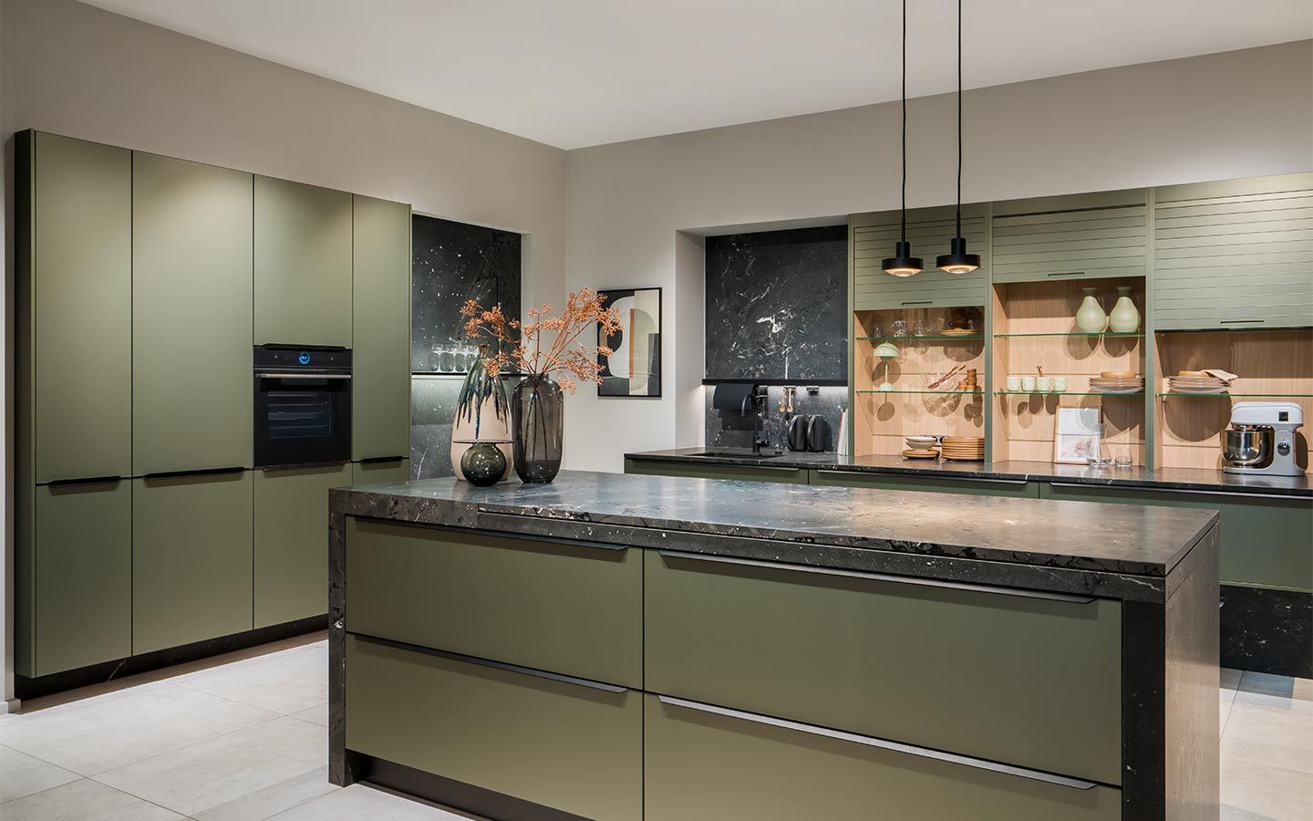 Grüne Küche mit dunklem Marmor Eine Grüne Küche mit Kochinsel in marmordesign