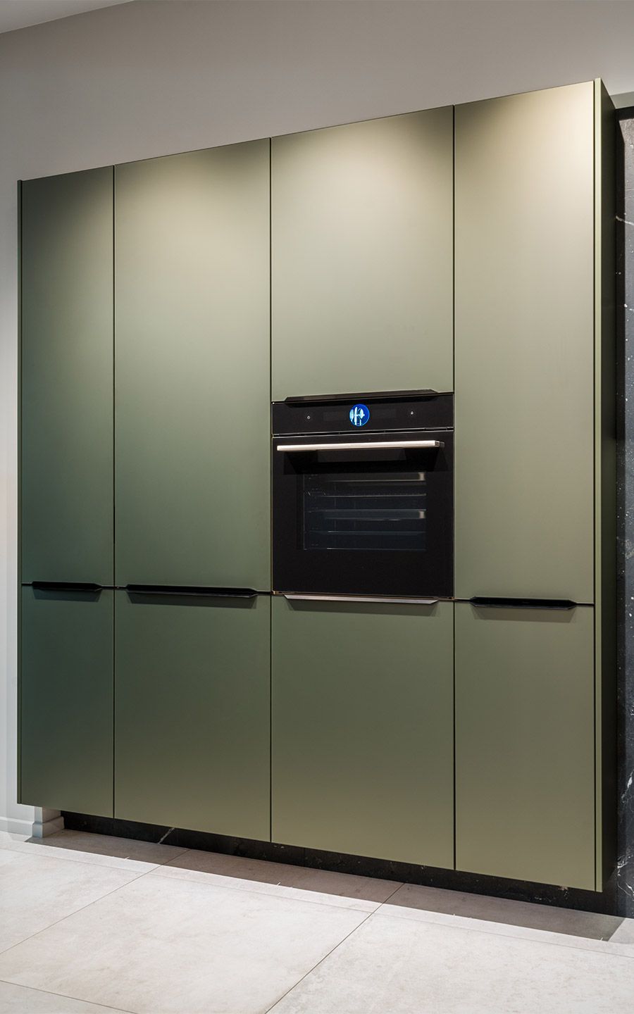 Olivgrüner Wandschrank Ein Olivgrüner Wandschrank mit eingebauten Ofen