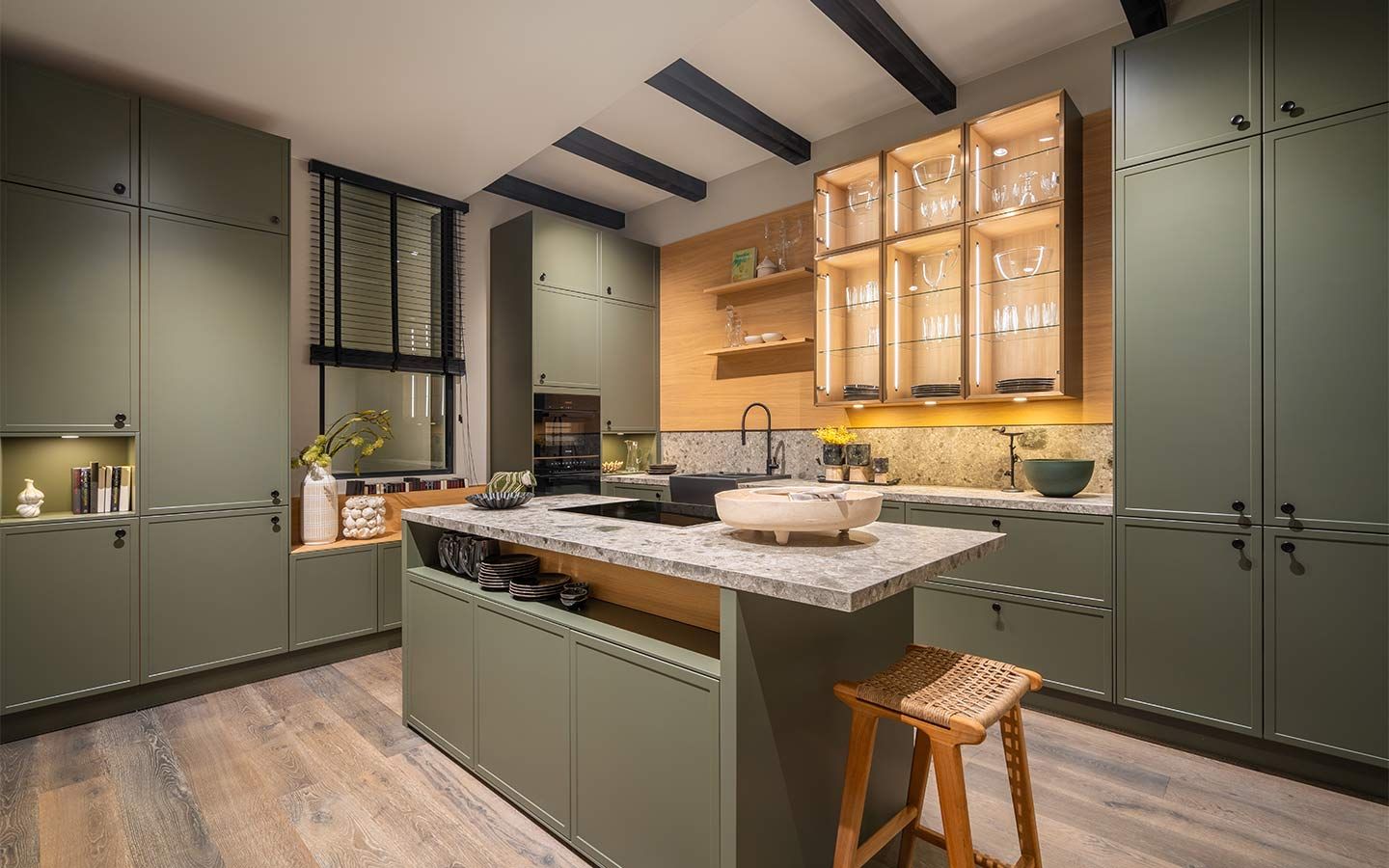 Grüne Küche mit Holzakzenten Eine grüne Küche mit einem hellen, hängenden Holzschrank mit Glastüren