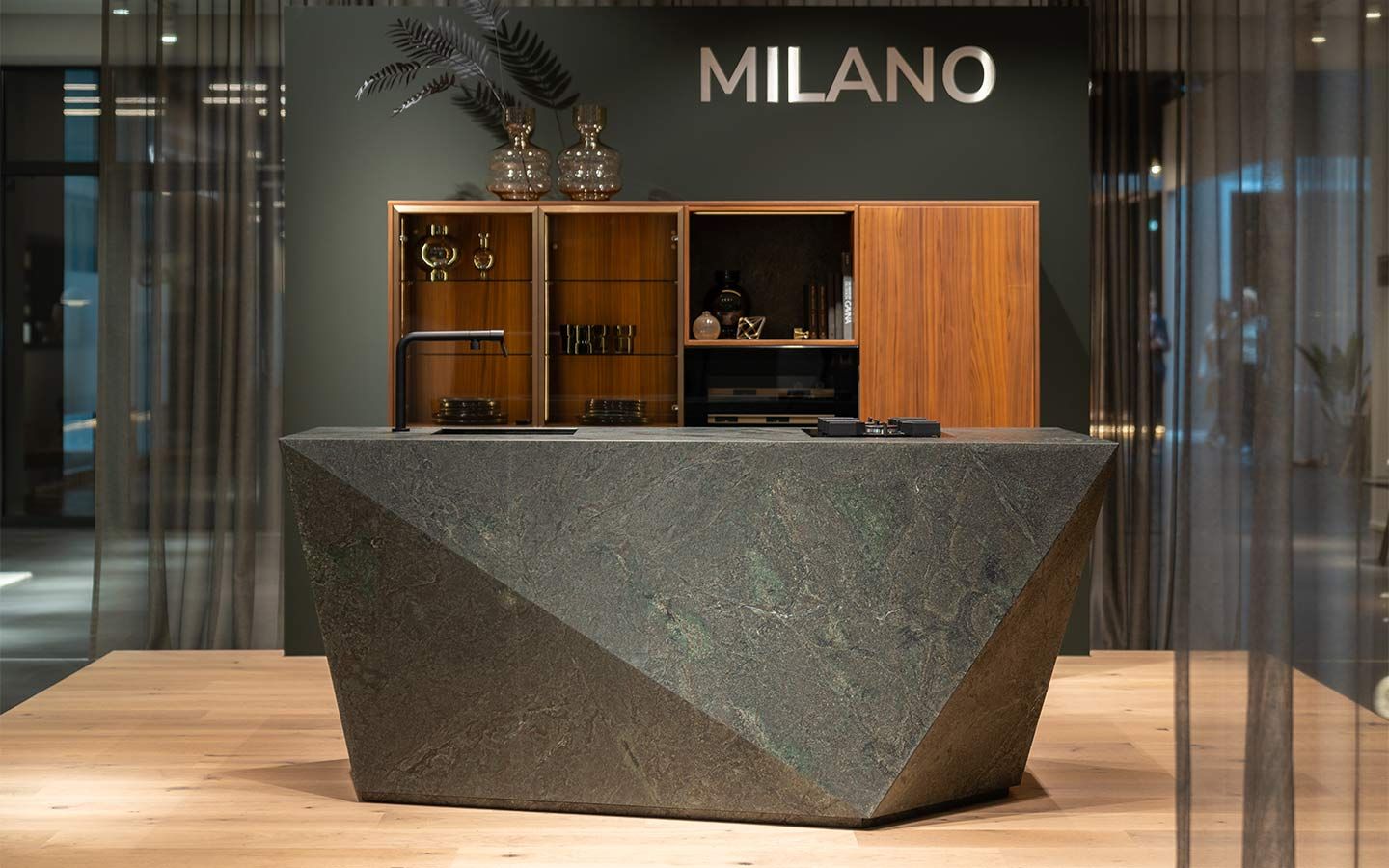 Designer Kücheninsel in eleganter Steinoptik Eine designer Kücheninsel mit Steinoptik auf Parkettboden und mit einem Schrank aus Naturholz