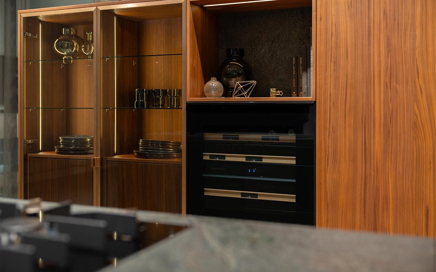 Küche mit Gasherd ind Holzoptik Eine Küche mit einer Naturholzoptik und schwarzem Ofen sowie Gasherd