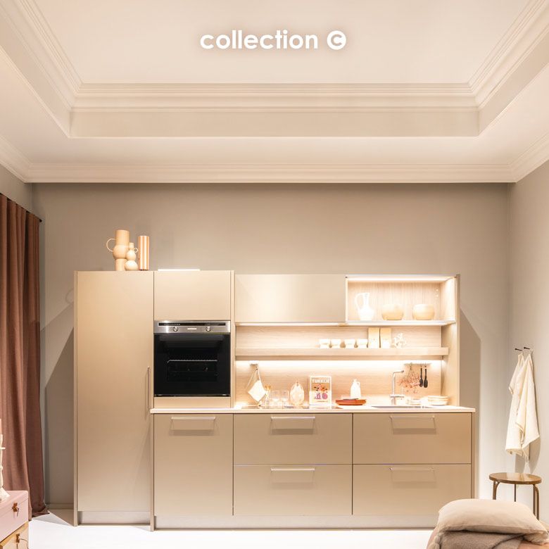 Eine beige Küche mit schwarzem Backofen in einem beigen Raum