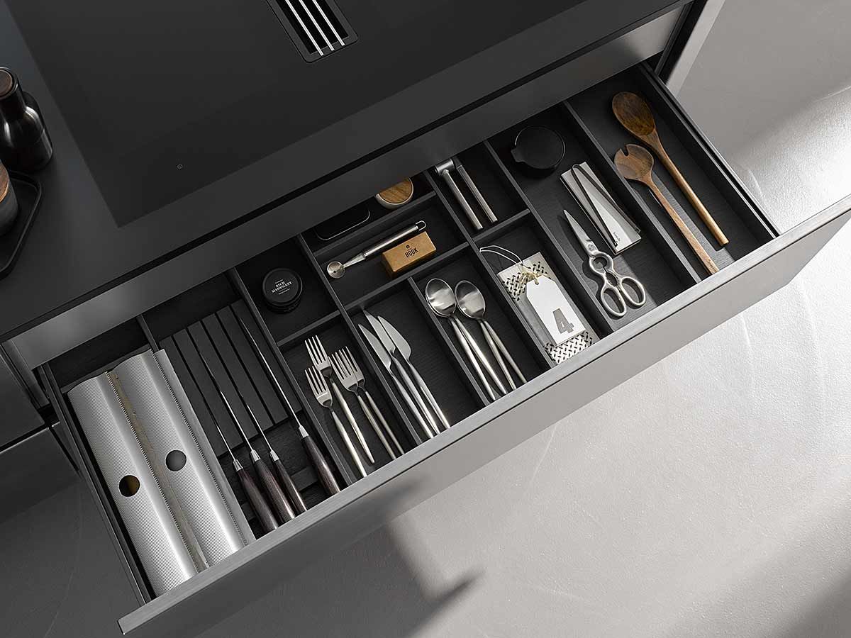 Besteckschublade Schwarz Geöffnete Besteckschublade unter schwarzer Kochplatte