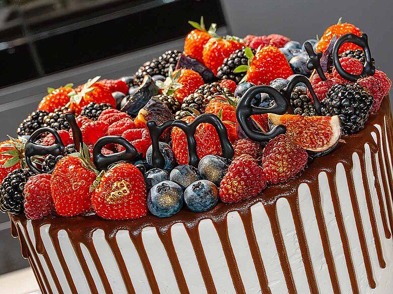 Kuchen elementa Ein Kuchen mit Früchten und elementa aus Schokoladenbuchstaben Buchstabiert